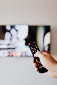 Person holding a tv remote